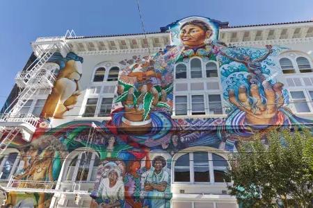 A colorful, large-scale mural covers the side of the Women's Building in San Francisco's Mission District.