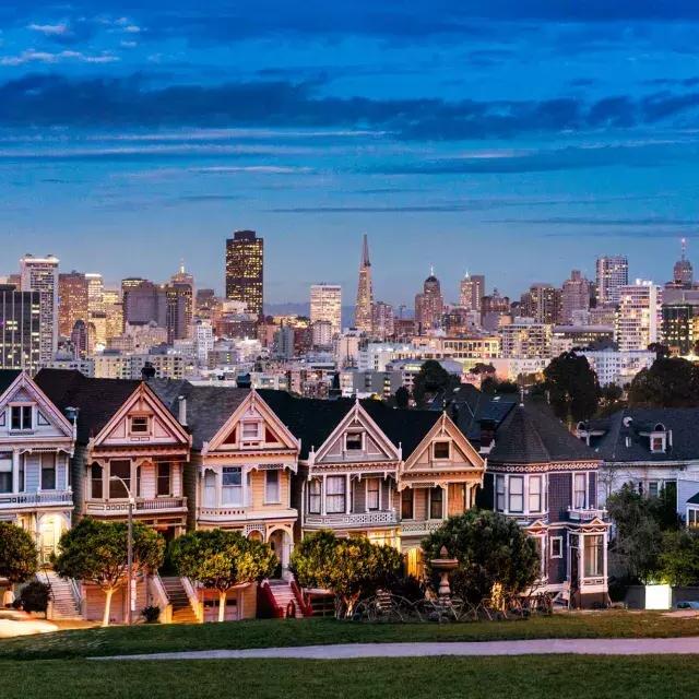The famous 涂女士 of Alamo Square are pictured before the 贝博体彩app skyline at twilight.